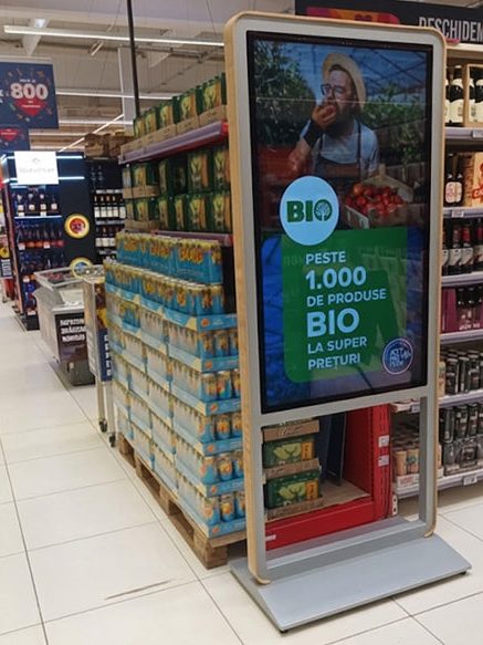 Totem LED cu o promoție pe culoarul unui supermarket